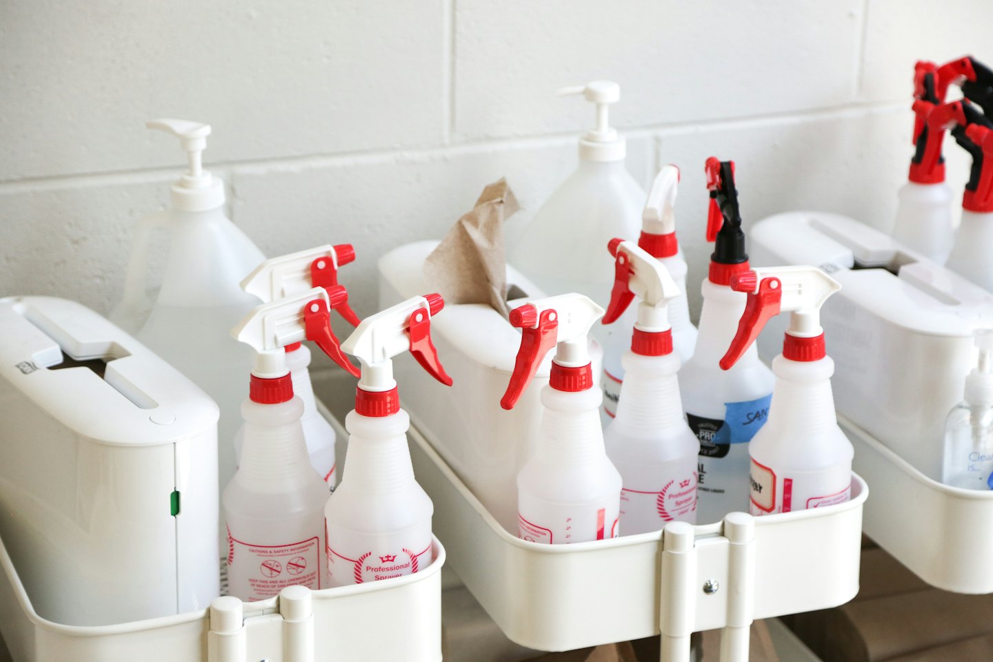 White spray bottles and tissue boxes on cleaning carts.